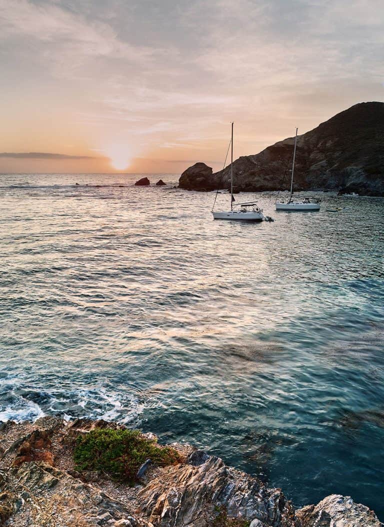 Two sailboats anchored at Little Harbor on Catalina Island at sunset.