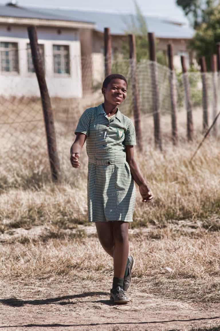 Swziland girl walking from school to a soccer game.